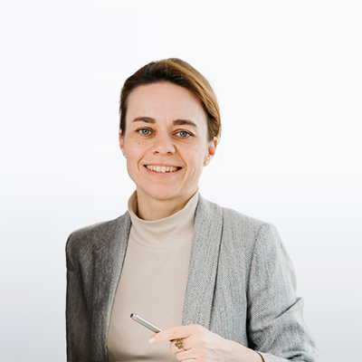 Portrait einer freundlich lächelnden Frau im hellem Rollkragenpullover und grauen Blazer hält einen Stift in der Hand